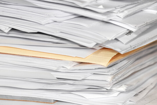 Stack of overflowing documents representing bureaucracy and paperwork overload