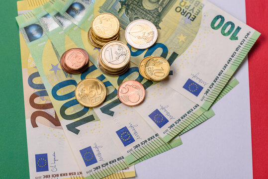 Italy, Italian euro cash and cent coins against the background of the flag. Euro cash