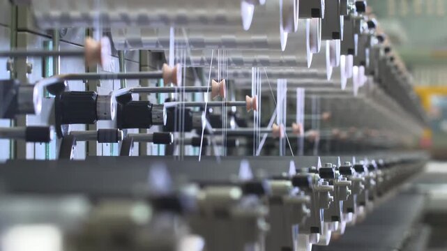 Industrial automation factory production line weaving plant of polypropylene yarn spools bags textile spinning machine industrial. White reels with ropes making plastic sacks or fabric process
