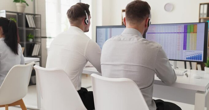 Operators agents support customers with headsets. In a bright office team agents handle service at monitors for clear helpdesk communication. Professional customer support teamwork concept.