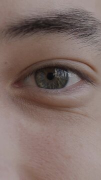 Close-up portrait of male eyes looking at camera with happiness while young man feeling joyful. Face expression and body part concept.