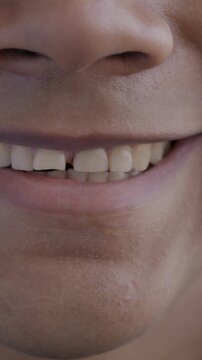Close-up portrait of male mouth smiling showing teeth expressing happiness on black background. People and positive emotion concept.
