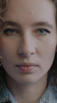 Close-up portrait of beautiful young lady looking at camera with serious face expression on black studio background. People and emotion concept.