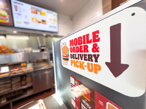 Calgary, AB, Canada. September 29, 2026. Close-up of mobile order and delivery pick-up sign inside a Burger King fast-food restaurant.