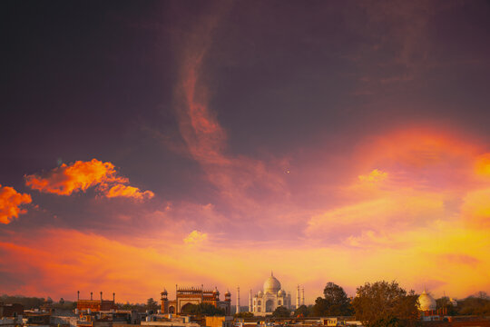 Taj Mahal and Agra cityscape at golden hour with warm sunset lighting