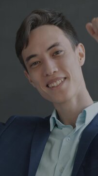 Slow motion portrait of cheerful young man in suit dancing looking at camera having fun on black studio background. People and dance concept.