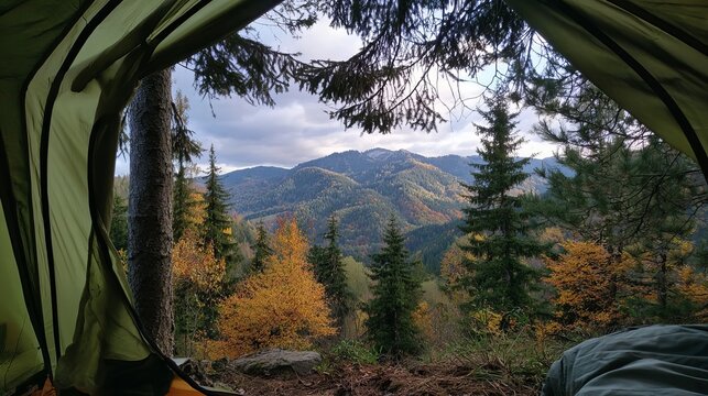 Scenic mountain landscape with colorful autumn forests viewed from inside a camping tent during daytime adventure travel