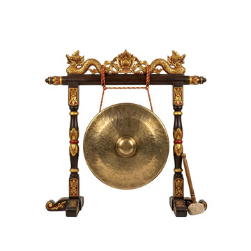 Traditional golden musical gong hanging on a carved wooden stand with mallet on transparent background