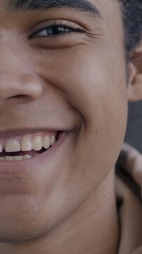 Close-up portrait if cheerful African American man half face looking at camera smiling laughing on black color background. People and positive emotion concept.