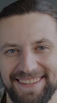 Close-up portrait of cheerful young man smiling looking at camera on black background. Positive emotion and happy person concept.