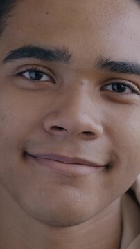 Close-up slow motion portrait of carefree African American man student smiling looking at camera on black color background. People and emotion concept.