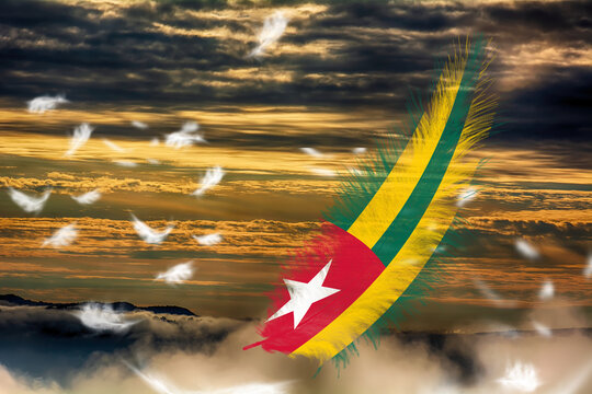 3D illustration. Flag of Togo on a feathers fluttering in the sky background.