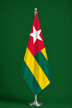 3D illustration. Flag of Togo on a ceremonial standing flag on a pole with a metal base.