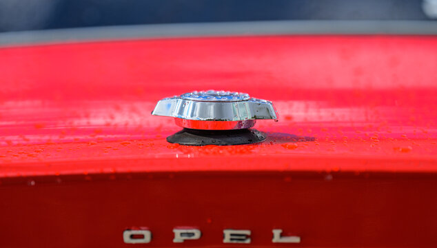 Trollh&auml;ttan, Sweden - August 22 2026: Chrome fuel cap on wet red Opel bodywork.