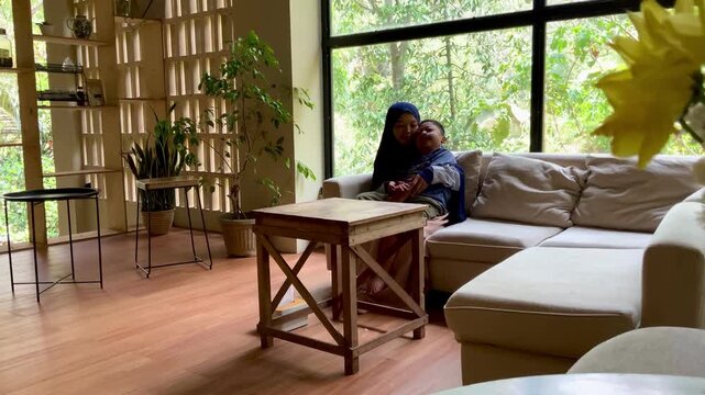 A scene of a mother and his child development delay sharing a tender, affectionate moment together in a bright, sunlit living room,