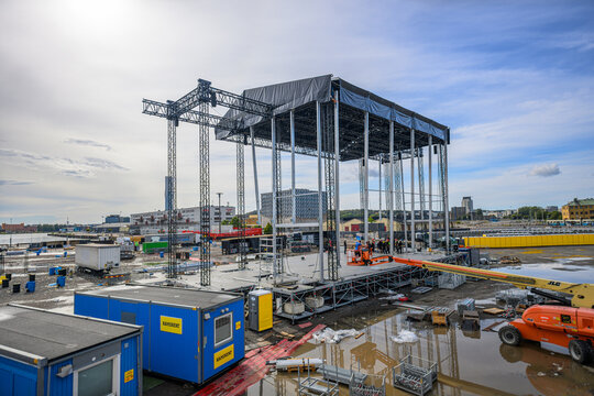 Gothenburg, Sweden - August 23 2026: Massive concert stage construction across muddy urban worksite.