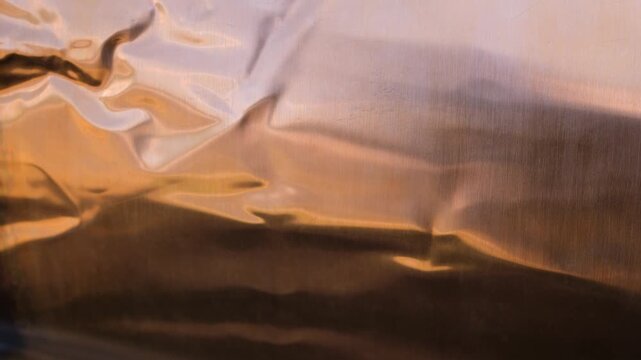 Flexible copper sheet. Abstract copper background with reflections and metallic color transitions. Selective focus. Copy space.