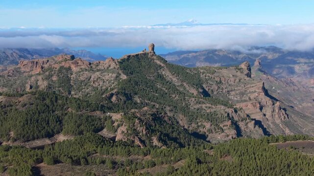 Aerial panorama of the Roque Nublo massif and its rock pinnacles, with Mount Teide on Tenerife rising above the sea of clouds, seen from Ga&ntilde;ifa