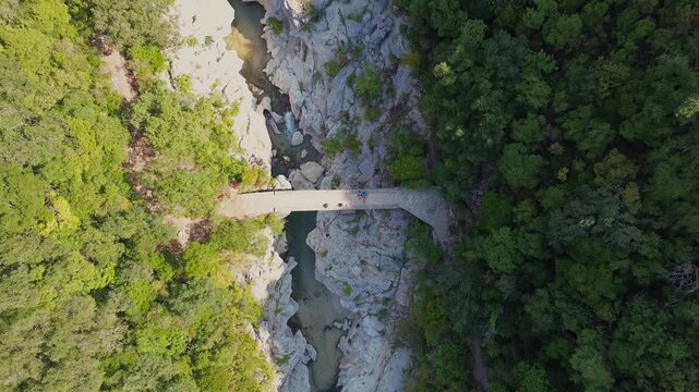 Drone rises above Dala Bridge revealing Acheron River and forest in Greece
