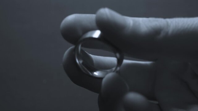 Black and white look at a gold wedding band in close up.