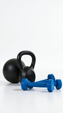 Essential gym tools including a kettlebell, medicine ball, and dumbbells, representing fitness, health, and exercise