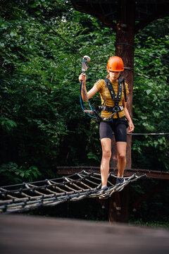 Woman navigating ropes course in adventure park