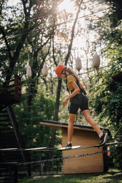 Young girl tackling rope adventure park challenge