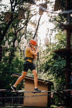 Teen girl navigating ropes course adventure park