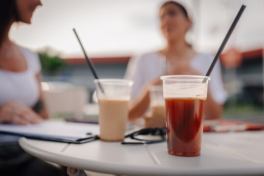 Friends drinking iced coffee during outdoor casual meeting