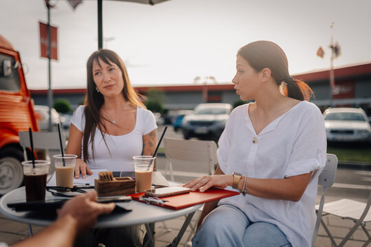 Business women discussing strategy at outdoor cafe