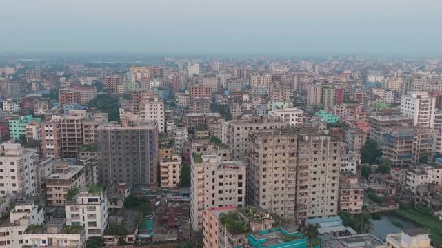 Buildings stretch across a densely populated urban landscape under a hazy sky. cityscape