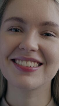 Slow motion portrait of attractive young lady smiling looking at camera on black color background. People and face expression concept.
