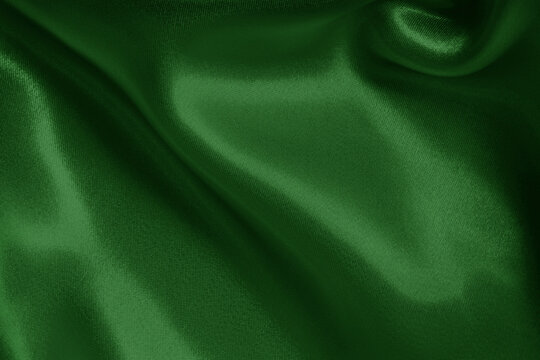 Dark green fabric cloth texture for background and design art work, beautiful crumpled pattern of silk or linen.