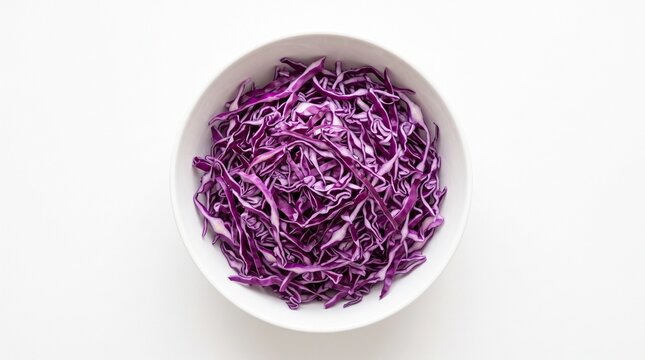 Shredded raw red cabbage in white bowl photographed from directly above on white background
