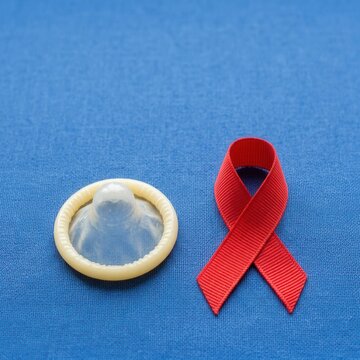 Condom And Red Ribbon Symbol For Aids Awareness And Safe Sex