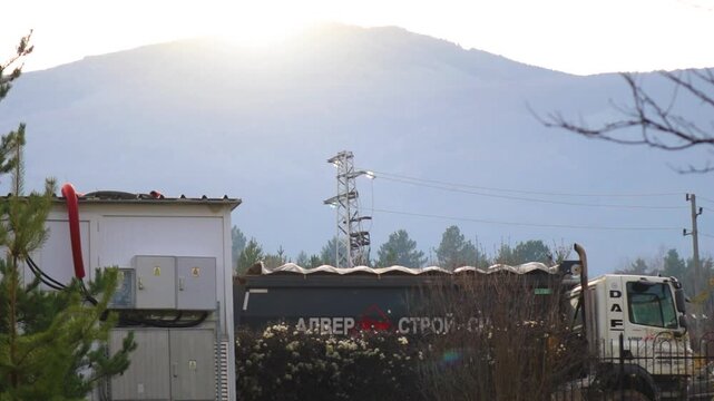 Sofia, Bulgaria - 09.30.2026, DAF dump truck parked near construction site with power lines and transformer station against Vitosha mountain view on sunny day