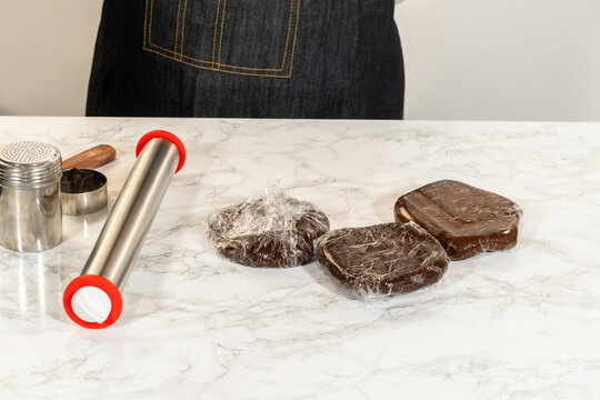 Wrapped chocolate dough portions with rolling pin