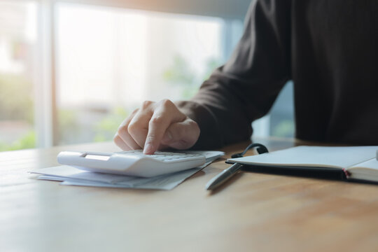 man hand press on calculator and check invoice letter from bank to check about debt and spending monthly for people lifestyle and inflation economic concept