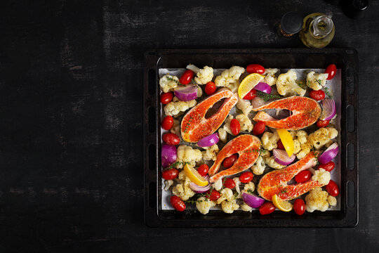 Top View of Uncooked Salmon and Vegetables on Sheet Pan