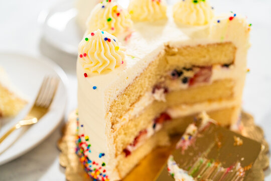 Side view of sliced birthday cake with spatula