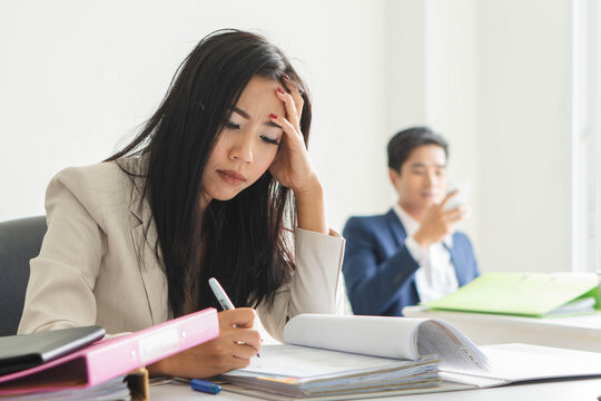 Asian female office worker feeling upset with her job and has a bored face expression at workplace