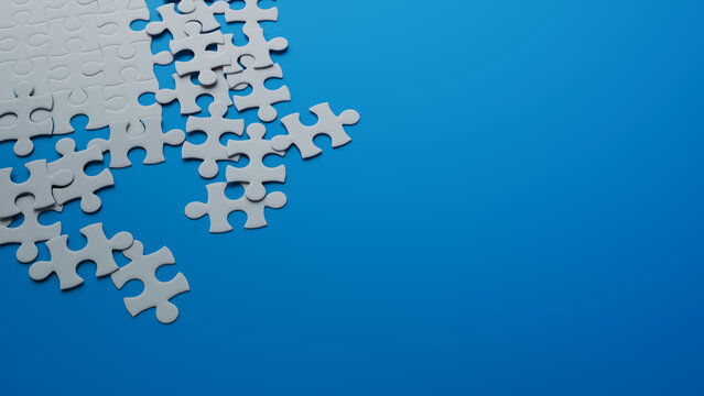 Partially Completed Blue and White Jigsaw Puzzle Backdrop with scattered Pieces. Growth Concept with copy-space.