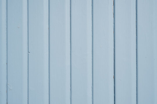 Light blue painted vertical wooden boards with subtle paint wear