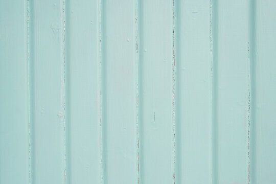 Mint green painted vertical wooden boards with subtle paint wear