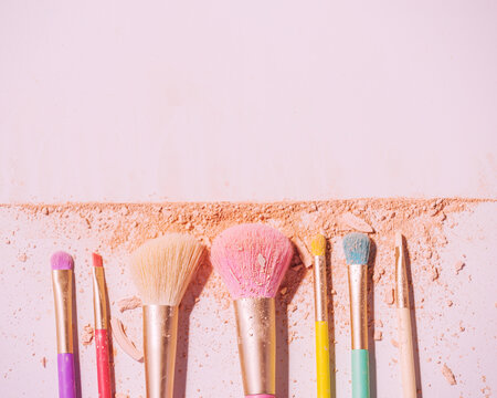 Make up brushes with powder on white background