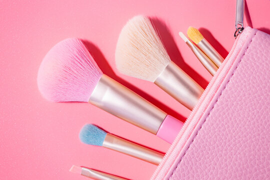 Make up brushes with powder on pink background