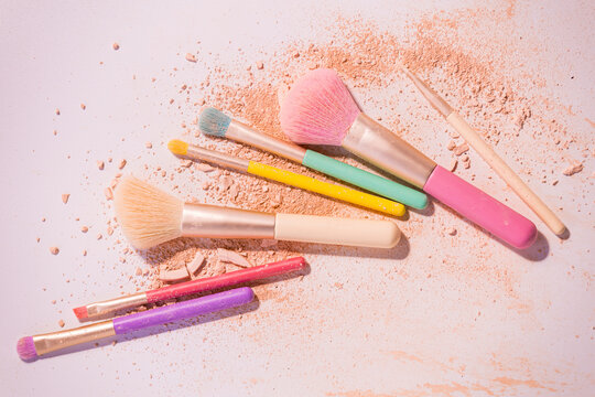 Make up brushes with powder on white background