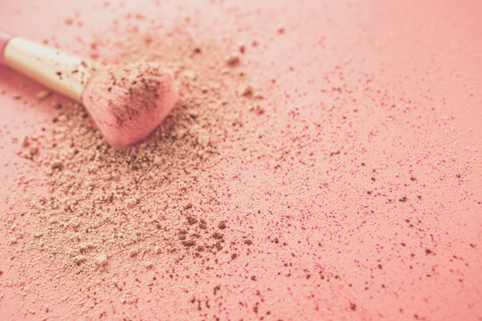 Make up brushes with powder on pink background