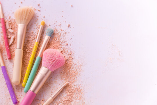 Make up brushes with powder on white background
