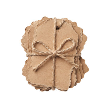 Stack of Handmade Brown Recycled Paper Tags Tied with a Twine Bow Isolated on White Background. Rustic Kraft Cardboard Labels for Gifts and DIY Crafts.